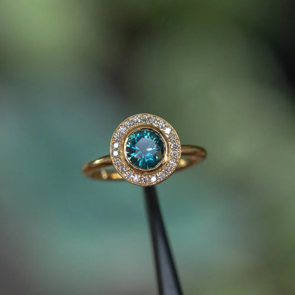 1.22ct Deep Teal Montana Sapphire With Bezel Set Diamond Halo In 18k Yellow Gold